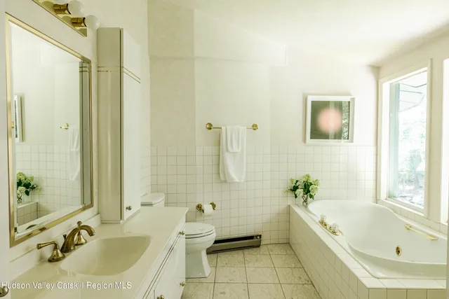 a bathroom with a tub sink and mirror