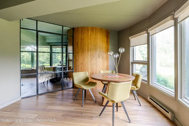 a living room with furniture a large window and wooden floor