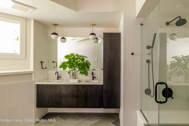 a bathroom with a shower sink and mirror