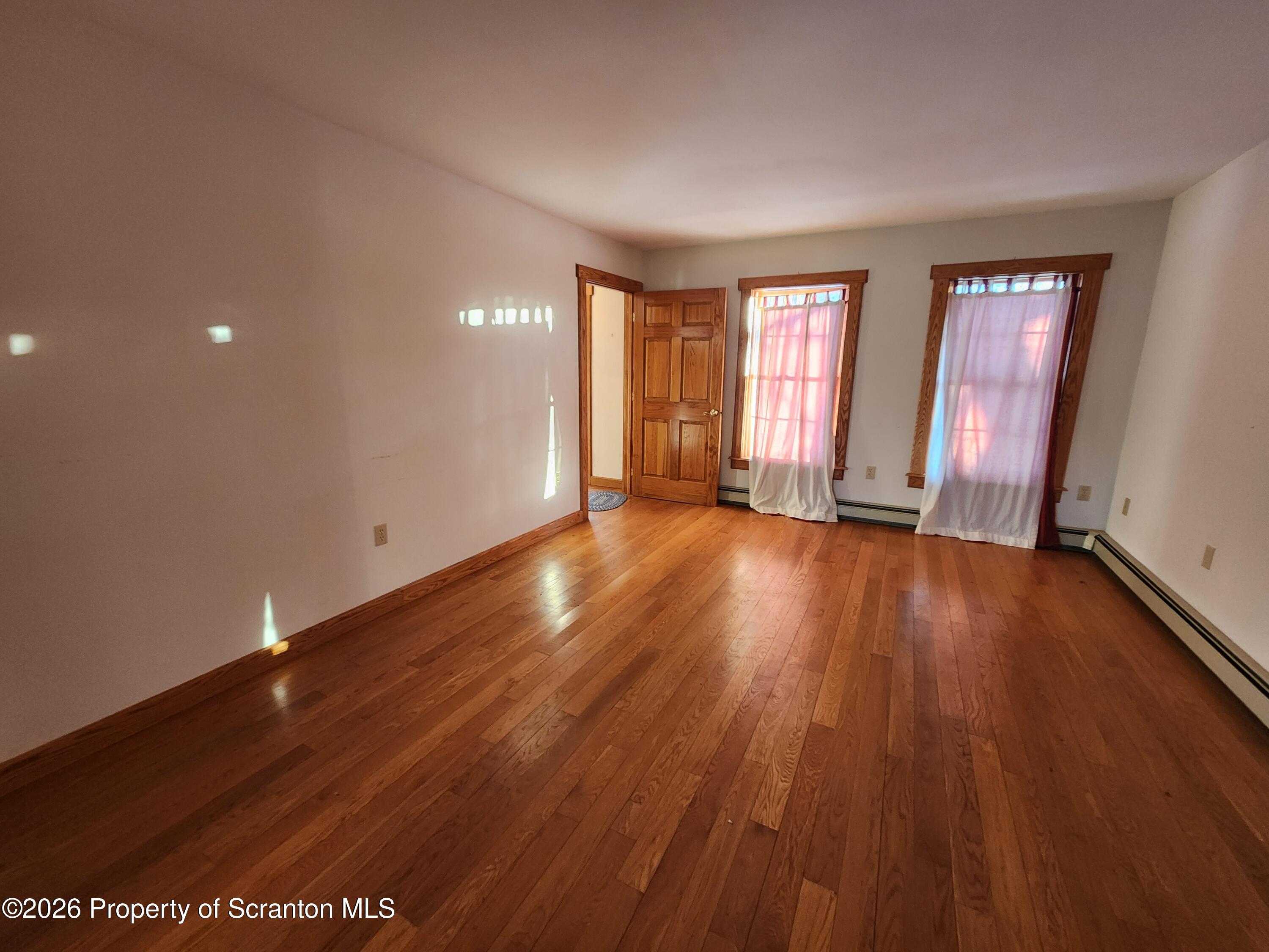 648 Dundaff Street Carbondale, PA 18407 - Photo 13 of 35 a view of an empty room with wooden floor and window