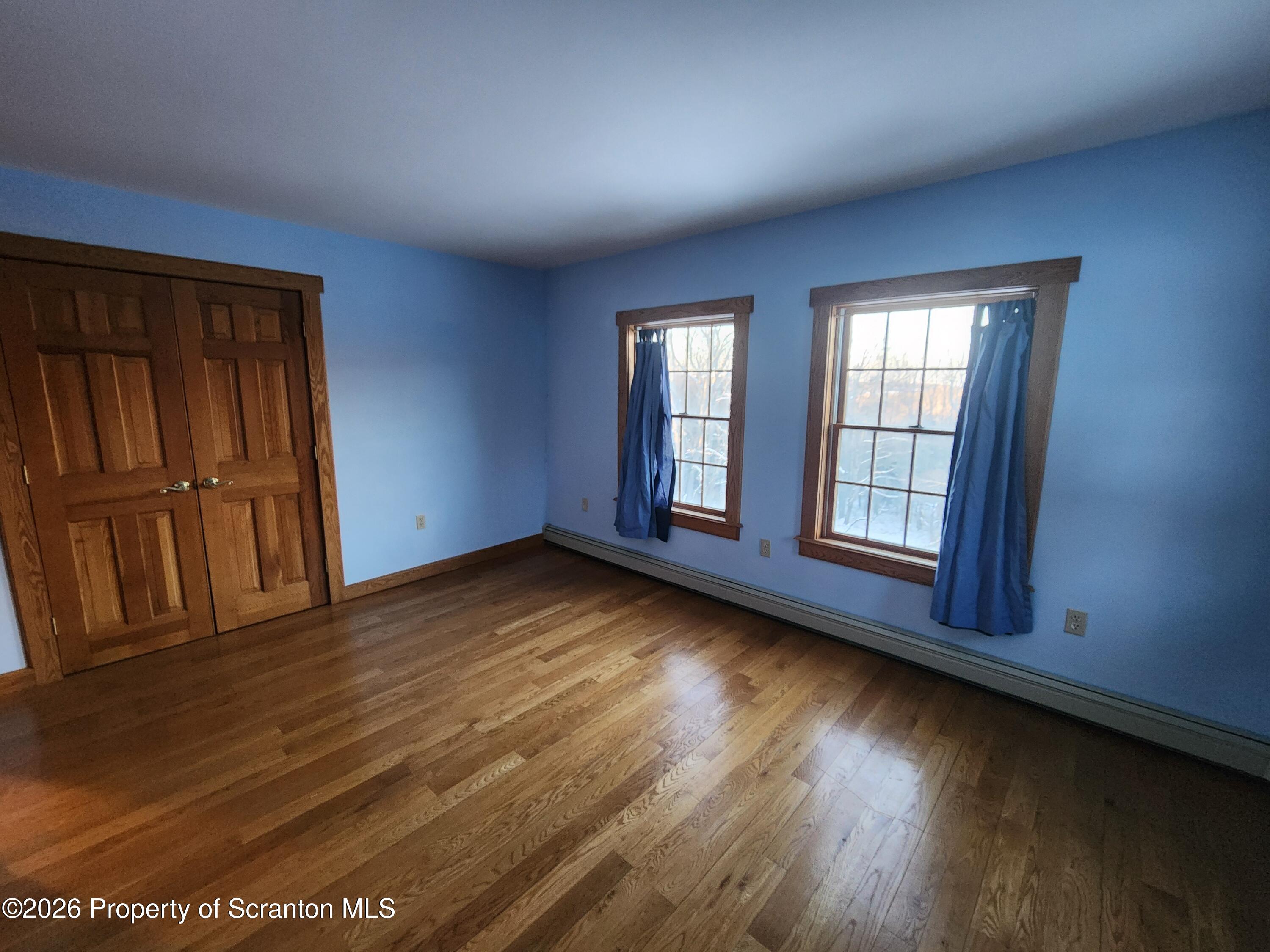 648 Dundaff Street Carbondale, PA 18407 - Photo 24 of 35 an empty room with wooden floor and windows