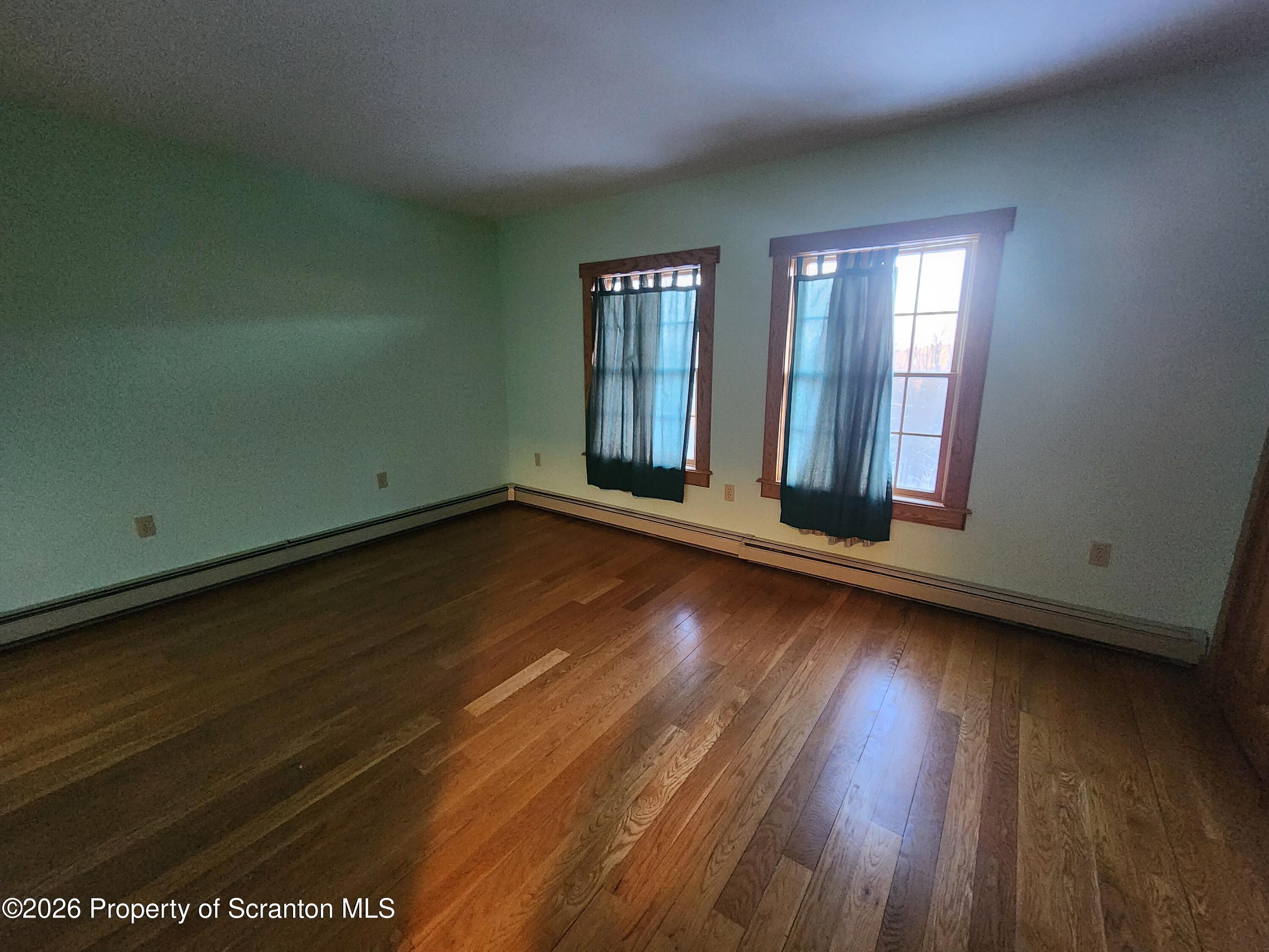 648 Dundaff Street Carbondale, PA 18407 - Photo 26 of 35 an empty room with wooden floor and windows