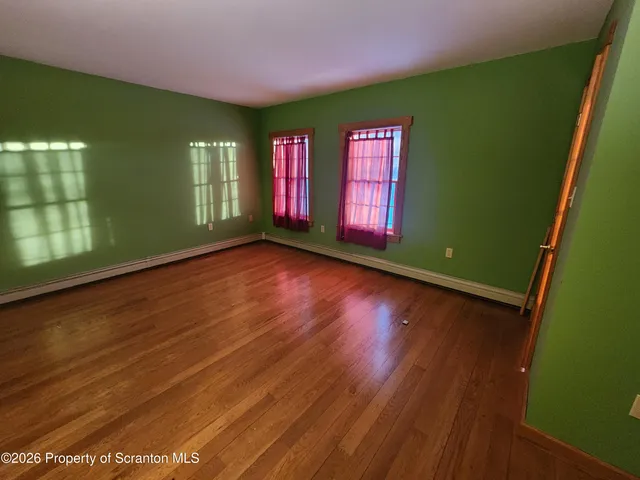 a view of room with window and wooden floor