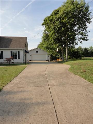 Wide concrete driveway which leads to a 2 car garage