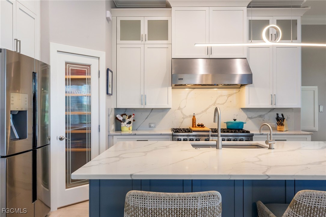 710 Birdie View Point Sanibel, FL 33957 - Photo 12 of 50 a kitchen with stainless steel appliances granite countertop a sink a stove and a refrigerator