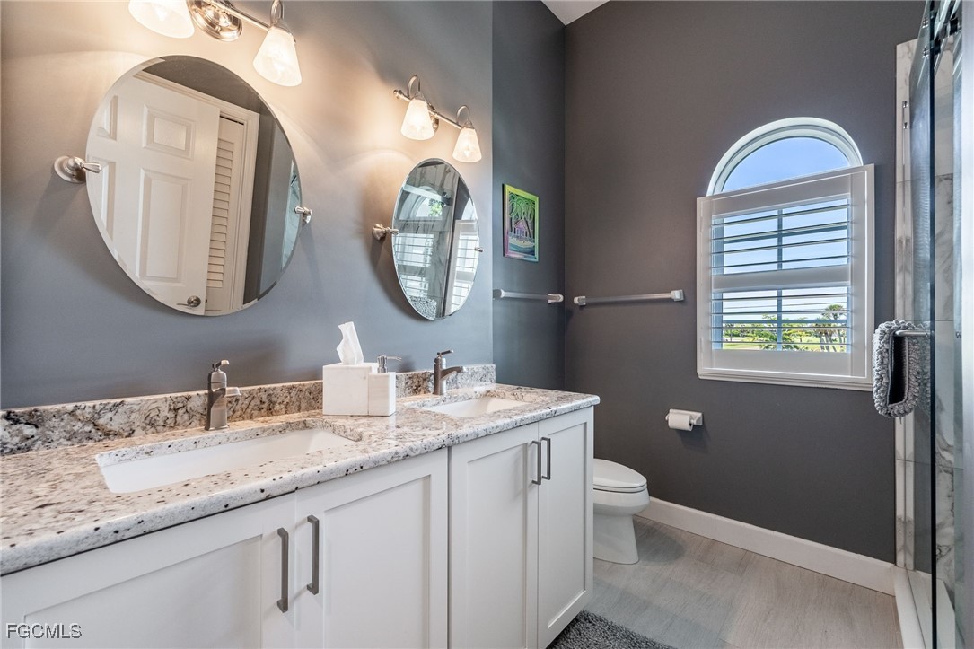 710 Birdie View Point Sanibel, FL 33957 - Photo 23 of 50 a bathroom with a granite countertop toilet a mirror and a sink