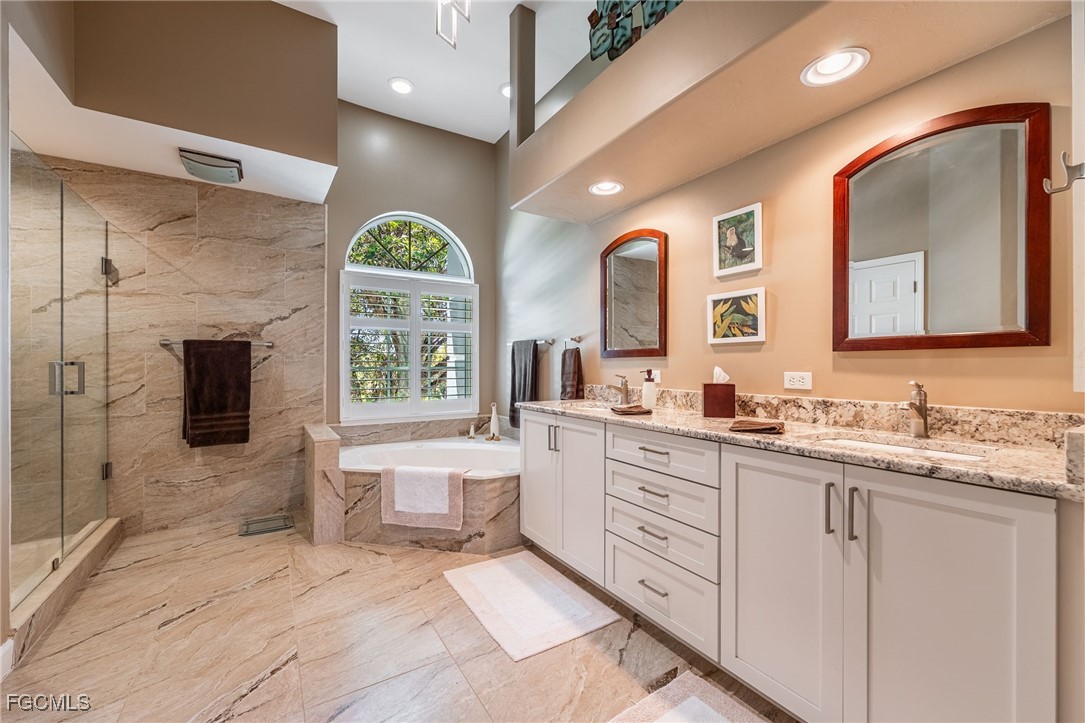 710 Birdie View Point Sanibel, FL 33957 - Photo 30 of 50 a spacious bathroom with a double vanity sink a mirror and a bathtub
