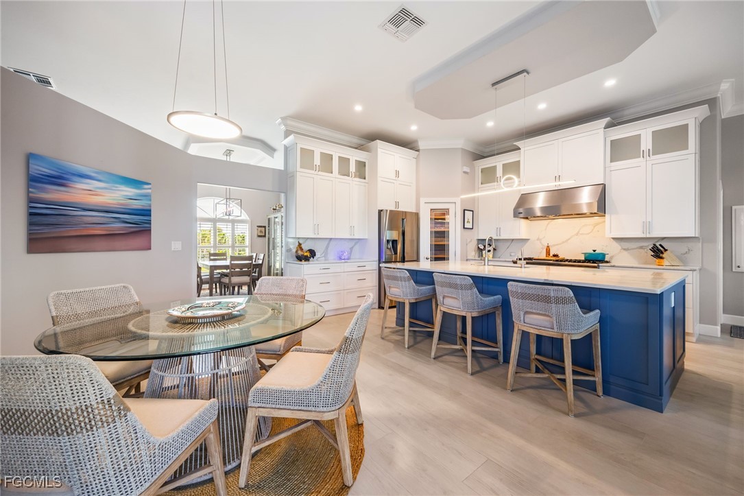 710 Birdie View Point Sanibel, FL 33957 - Photo 10 of 50 a dining room with stainless steel appliances kitchen island granite countertop a dining table chairs and a refrigerator