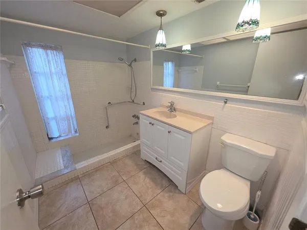 a bathroom with a toilet a sink a mirror a vanity and window