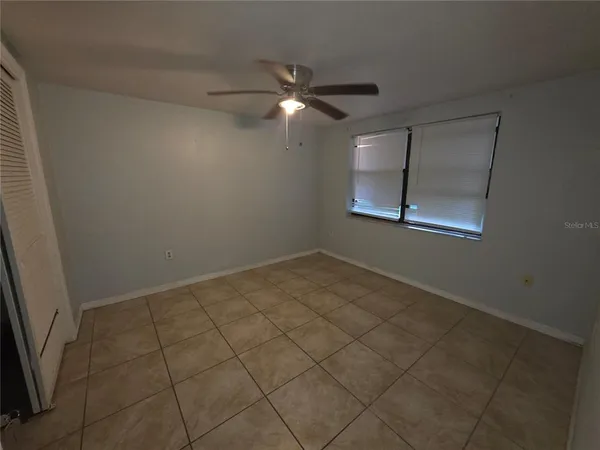 an empty room with closet and fan