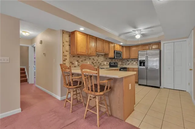 a kitchen with stainless steel appliances kitchen island granite countertop a refrigerator and cabinets