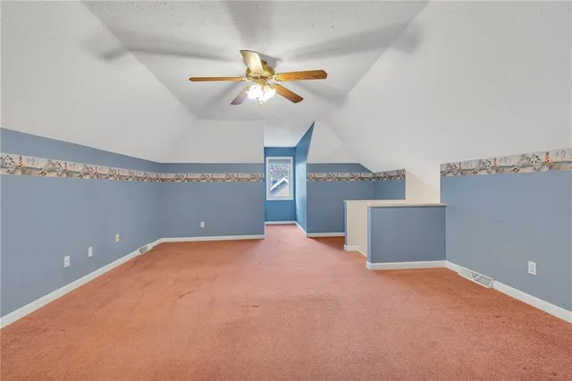 a view of a room with a ceiling fan and window