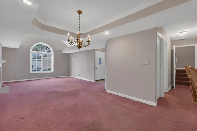 a view of a livingroom with a chandelier fan and windows