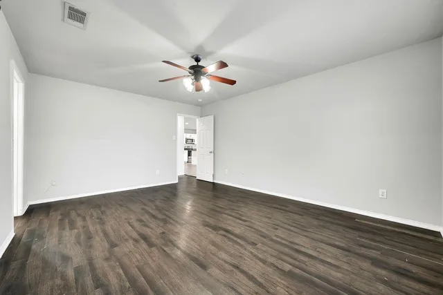 a view of an empty room with wooden floor