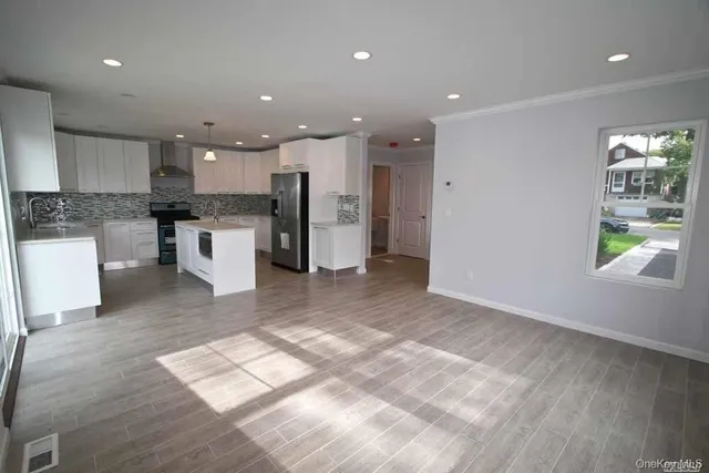 a view of kitchen with stainless steel appliances kitchen island granite countertop a refrigerator and a sink