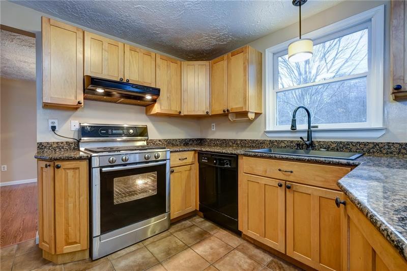 402 Three Degree Road Renfrew, PA 16053 - Photo 8 of 25 Open & updated eat-in kitchen with farmhouse sink, gas SS stove, granite, and quality cabinetry.