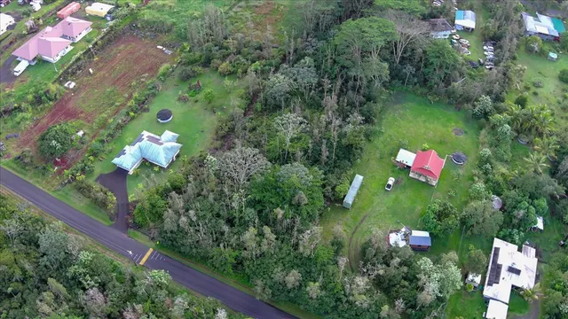 an aerial view of a residential houses with yard and green space