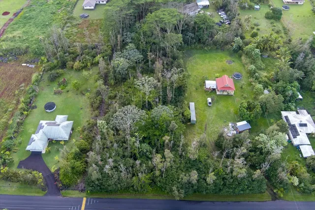 an aerial view of residential house with outdoor space and trees all around