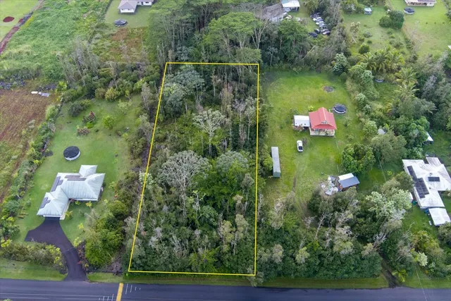 an aerial view of residential house with outdoor space and trees around