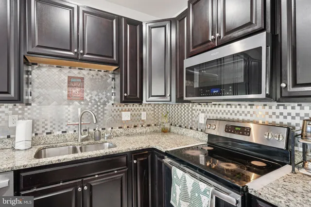 a kitchen with granite countertop a stove and a sink