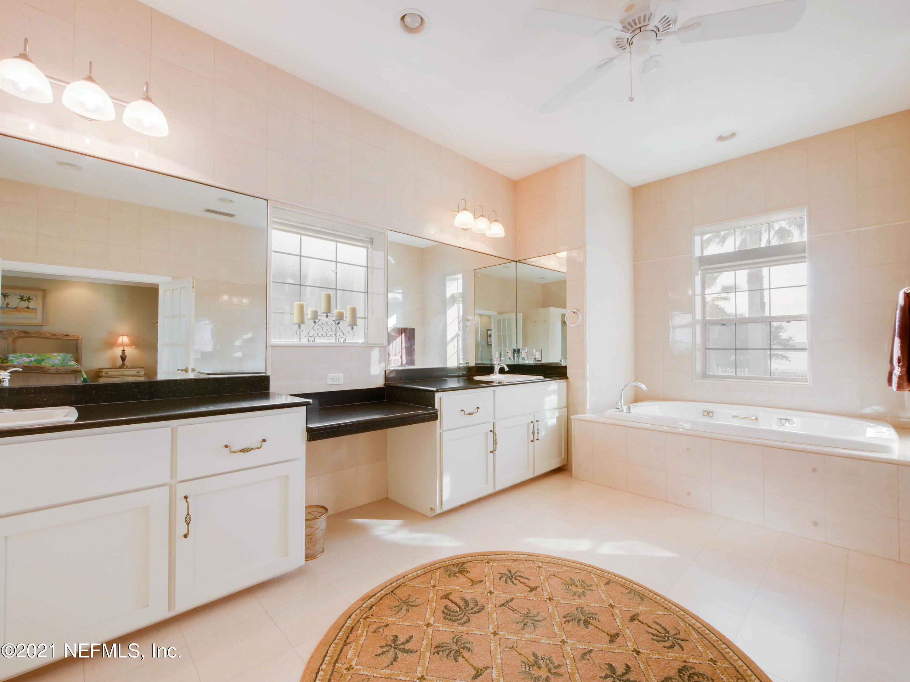 8115 A1A South St. Augustine, FL 32080 - Photo 26 of 50 a large white kitchen with granite countertop a sink white cabinets and white appliances
