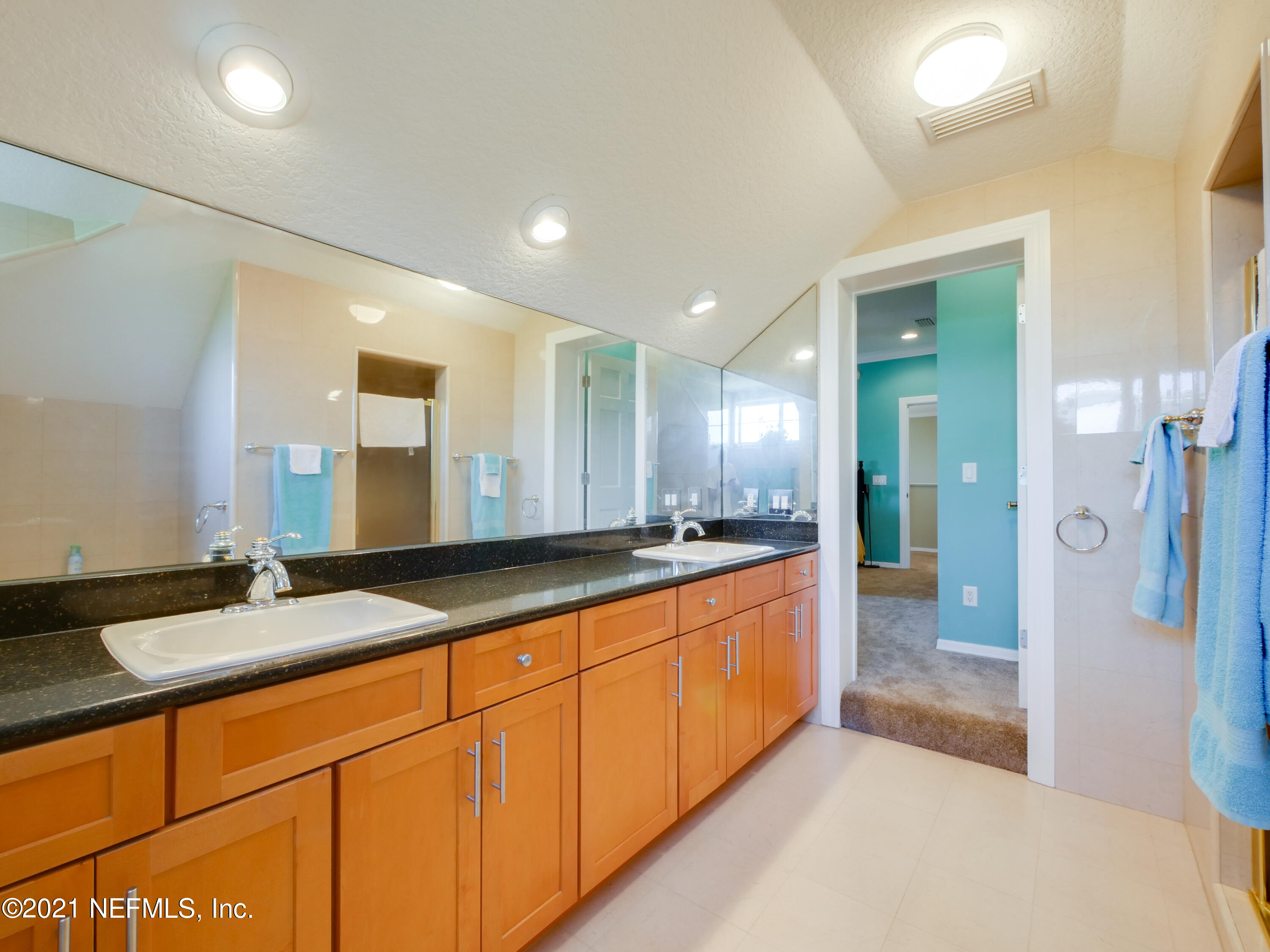 8115 A1A South St. Augustine, FL 32080 - Photo 34 of 50 a large bathroom with a granite countertop sink and a mirror
