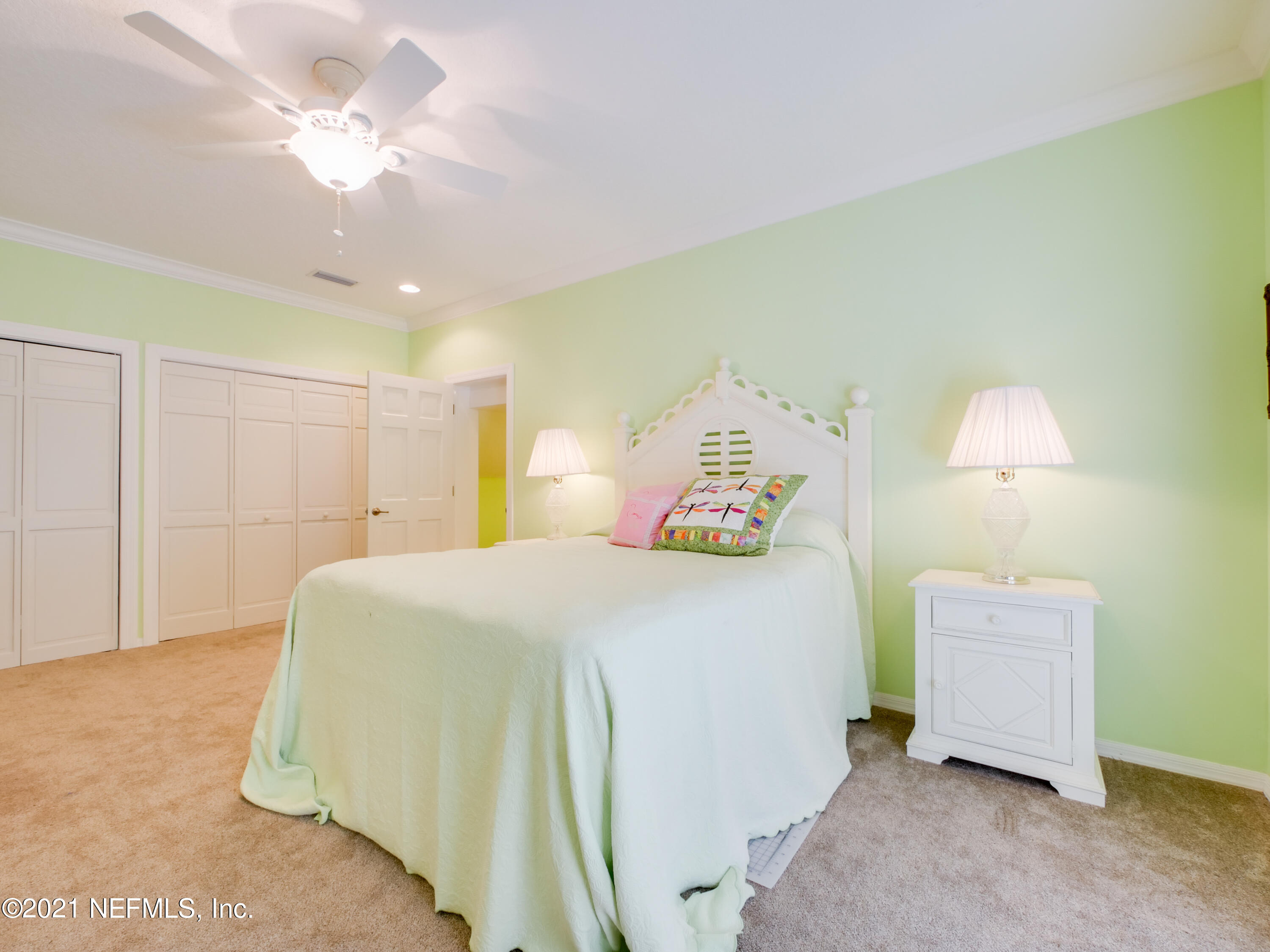 8115 A1A South St. Augustine, FL 32080 - Photo 40 of 50 a spacious bedroom with a bed and a chandelier