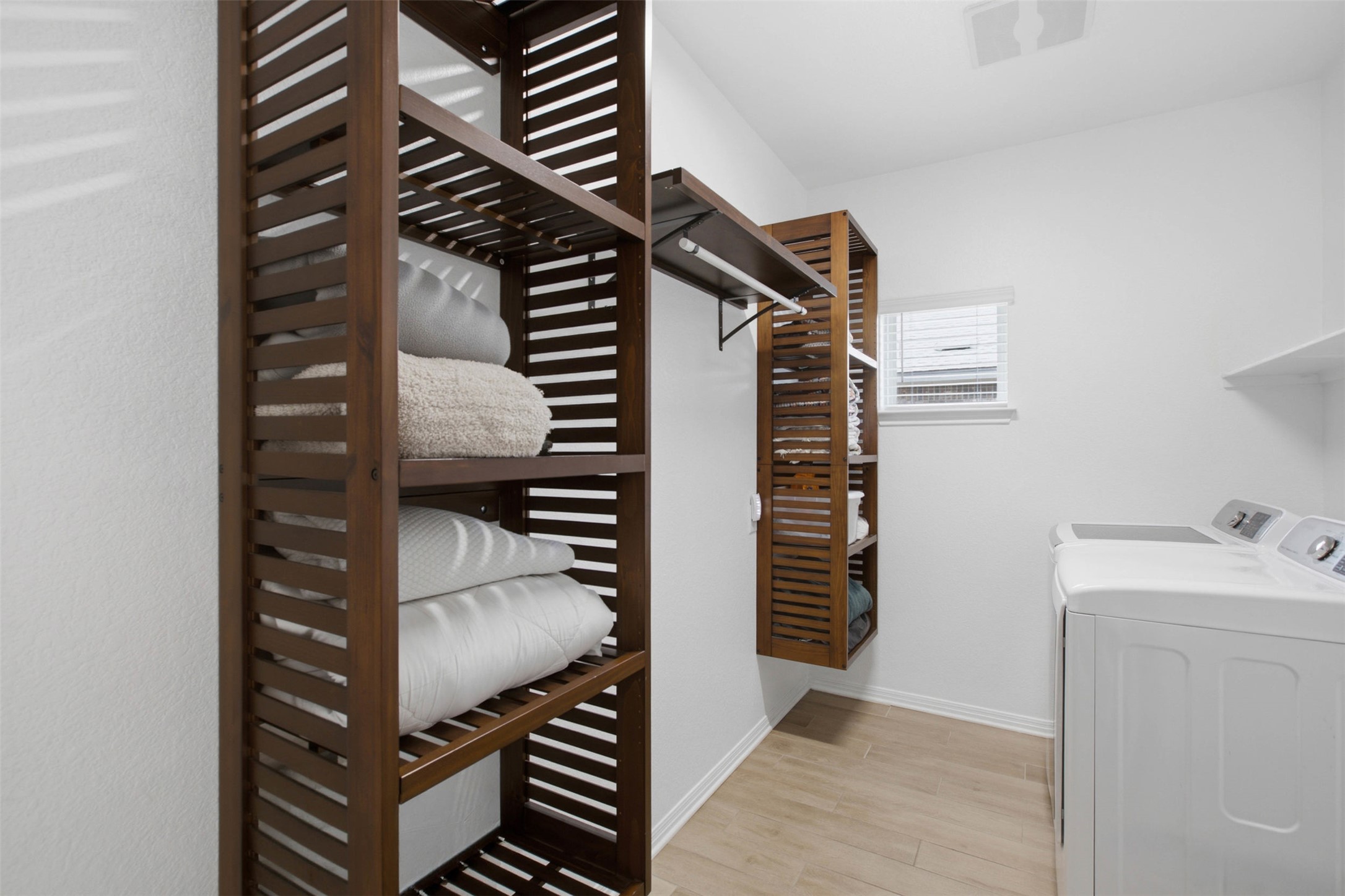 2413 Bridges Ranch Road Georgetown, TX 78628 - Photo 13 of 31 Functional laundry space featuring durable wood-look flooring and custom shelving.