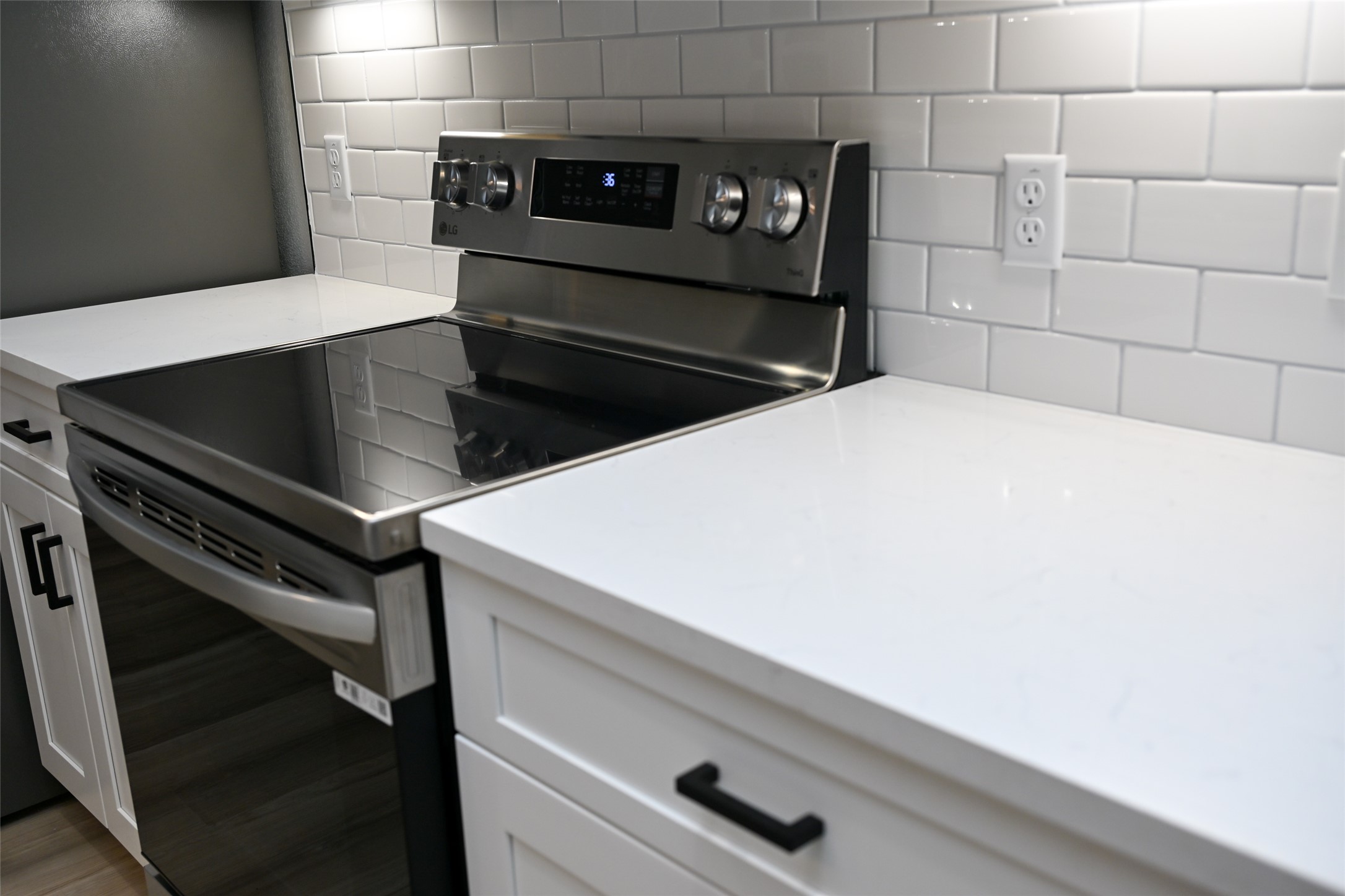 516 North Hackberry Avenue Luling, TX 78648 - Photo 20 of 36 Kitchen featuring stainless steel electric stove, white cabinetry, and light stone countertops