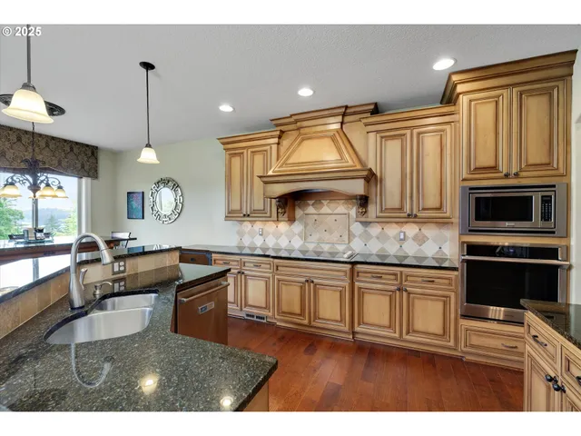 a kitchen with kitchen island granite countertop a stove a sink and a microwave