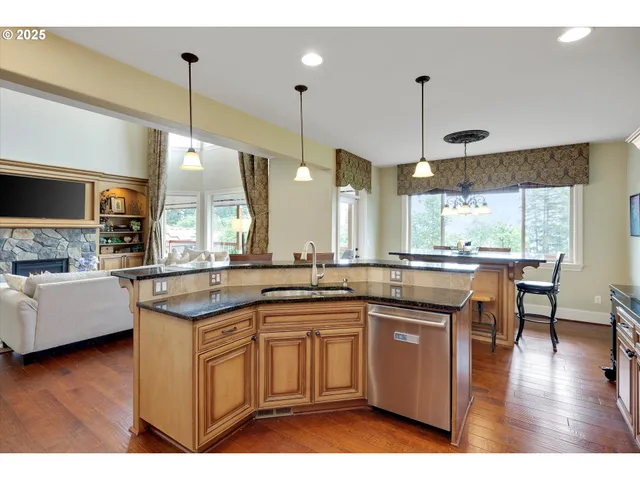 a kitchen with granite countertop a sink a counter space appliances and a floor