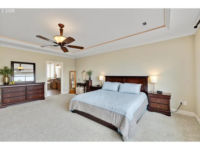 a bedroom with a large bed and ceiling fan