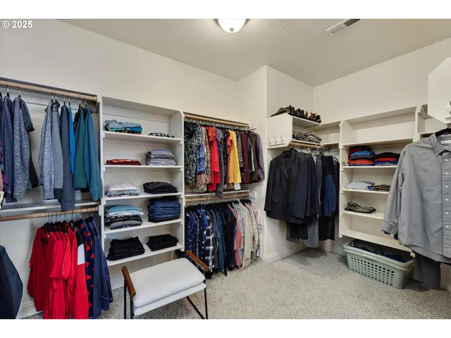a view of walk in closet with clothes and shoes
