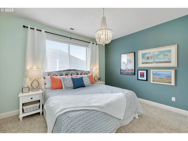 a bedroom with a large bed and a chandelier