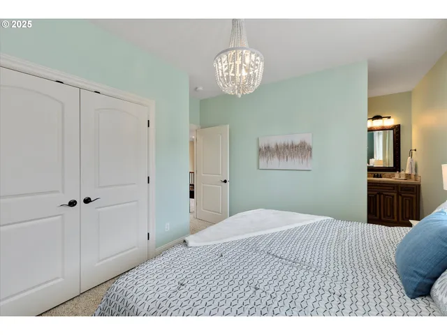 a bedroom with a large bed and a chandelier