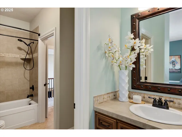 a bathroom with a granite countertop sink a mirror a vanity and a shower