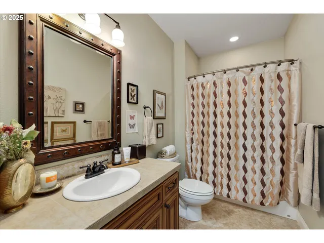 a bathroom with a granite countertop sink toilet and a mirror