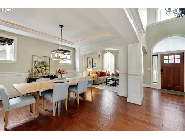 a view of a dining room and livingroom with furniture wooden floor a chandelier