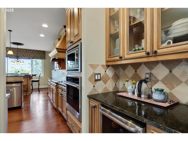 a kitchen with granite countertop stainless steel appliances and wooden cabinets