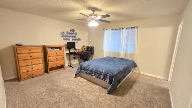 a spacious bedroom with a bed and a dresser