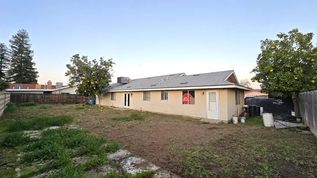a view of a house with backyard and trees