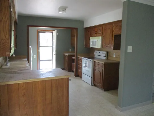a kitchen with stainless steel appliances granite countertop a sink a stove and a refrigerator