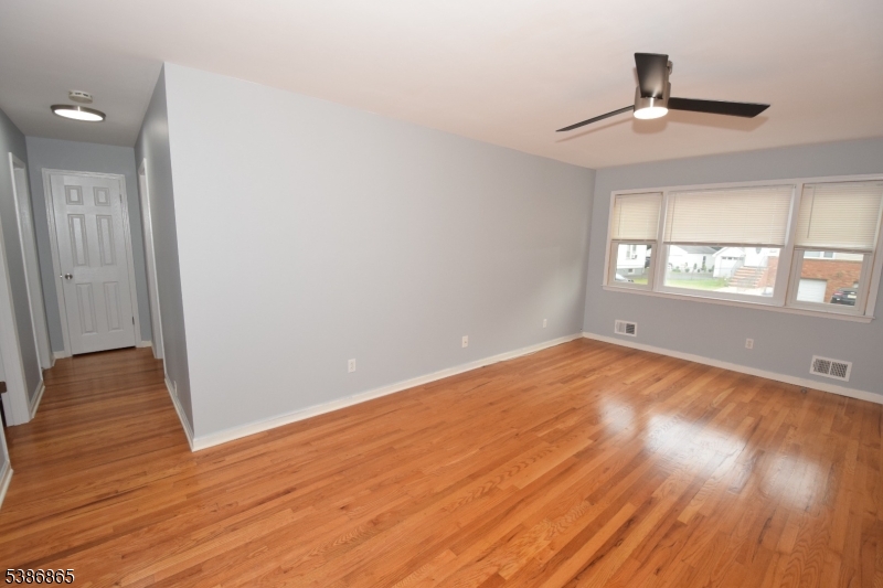 40 Glaser Avenue Raritan, NJ 08869 - Photo 17 of 28 an empty room with wooden floor chandelier fan and windows