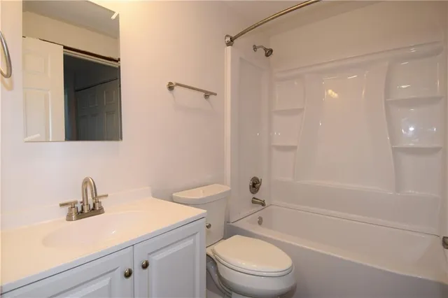 an empty room with a hallway and wooden floor