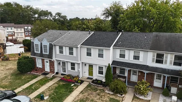 a aerial view of a brick house next to a yard