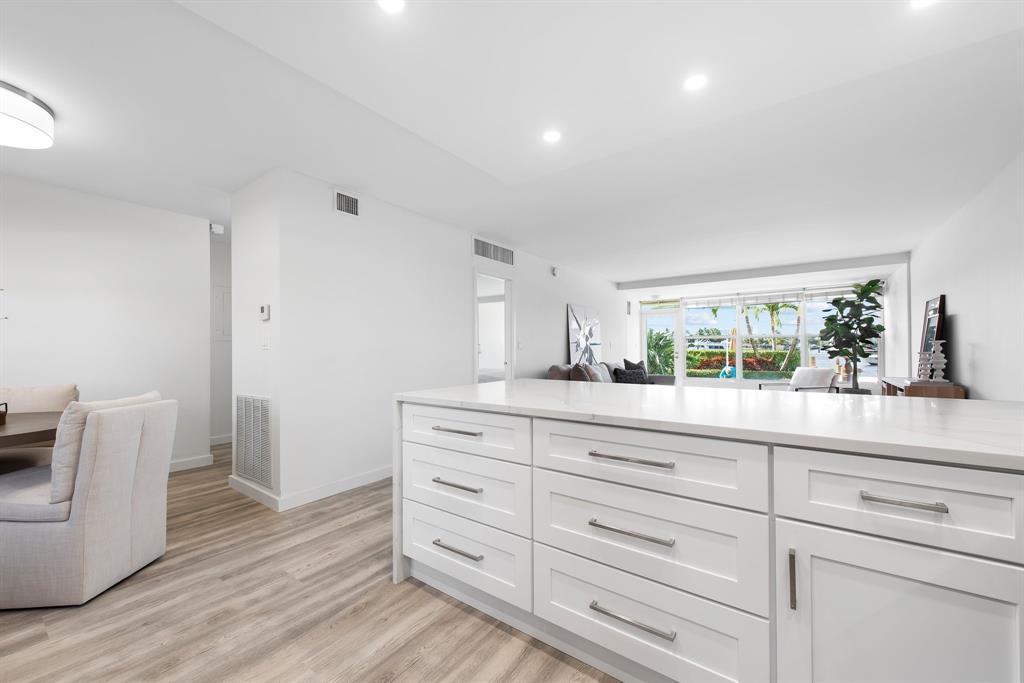215 North Birch Road, Unit 1C Fort Lauderdale, FL 33304 - Photo 9 of 21 a sink with white cabinets and wooden floor