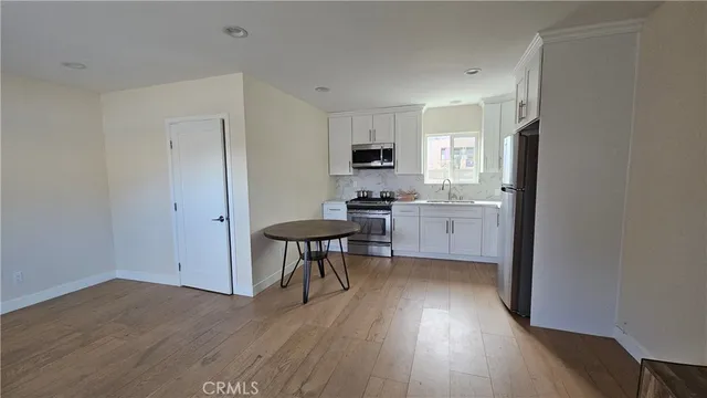 a kitchen with granite countertop a sink cabinets and wooden floor