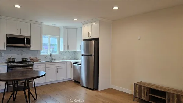 a kitchen with a refrigerator and a stove top oven