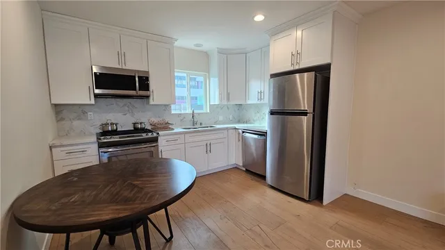 a kitchen with a refrigerator a microwave a sink and a stove