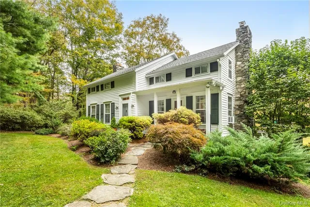 a front view of a house with a yard and potted plants